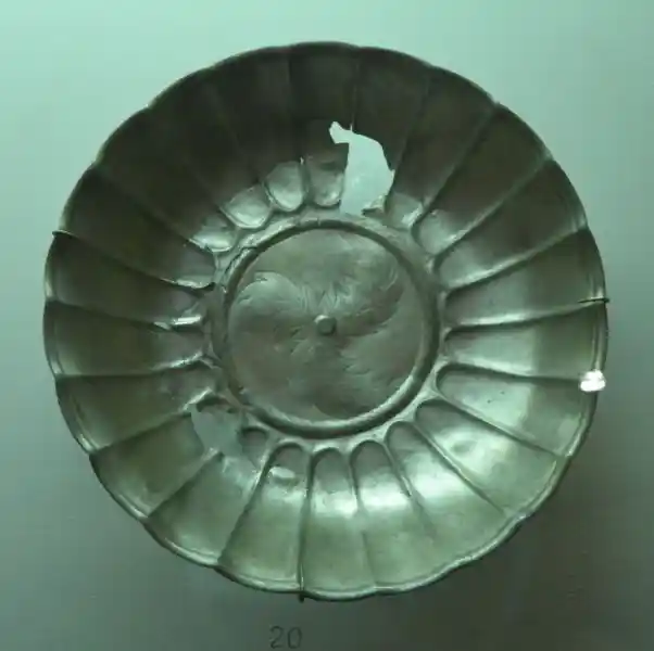 A three-pointed cross in the center of a silver bowl